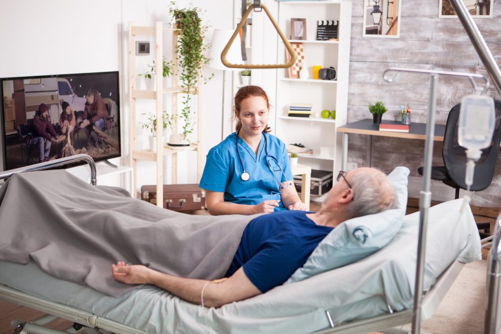 Female doctor with stethoscope sharing comfort to old man